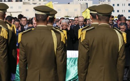 Palestinian President Mahmoud Abbas (C) prays next to the coffin of Palestinian minister Ziad Abu Ein during his funeral in the West Bank city of Ramallah December 11, 2014. REUTERS/Ammar Awad