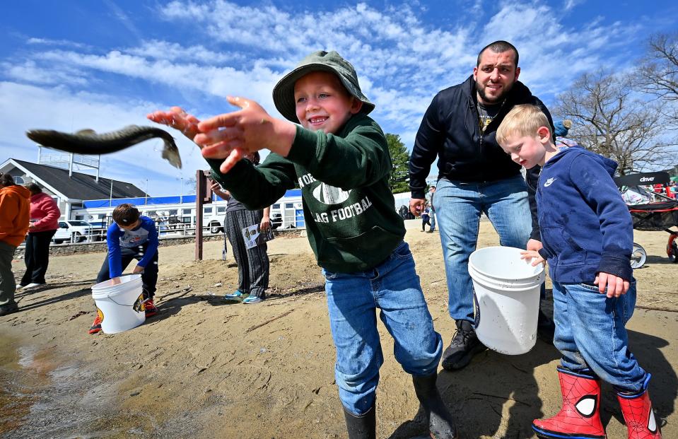 Lucas Roman, 5, and his father, Nick, and brother, Samuel, 3, were among those at Regatta Park who helped restock Lake Quinsigamond with trout.