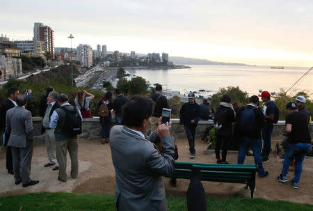 People stand and watch the ocean on Cerro Castillo hill, after a mass evacuation of the entire coastline during a tsunami alert after a magnitude 7.1 earthquake hit off the coast in Vina del Mar, Chile April 24, 2017 REUTERS/Rodrigo Garrido