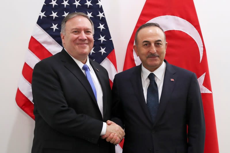 U.S. Secretary of State Pompeo poses with Turkish Foreign Minister Cavusoglu during a NATO foreign ministers meeting in Brussels