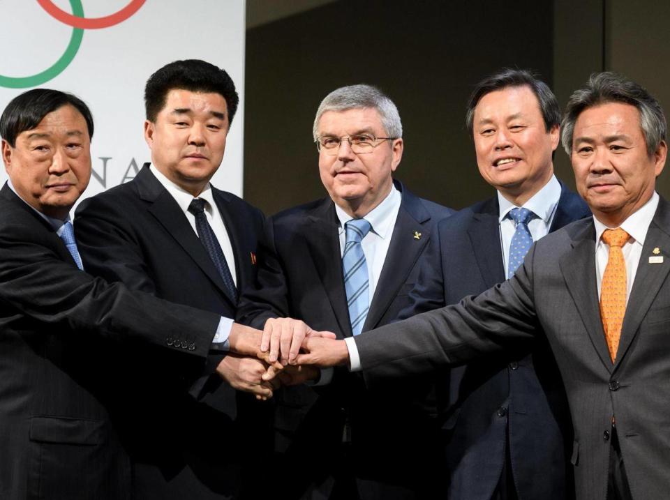 Delegates from both countries join hands with the IOC president Thomas Bach (Getty)