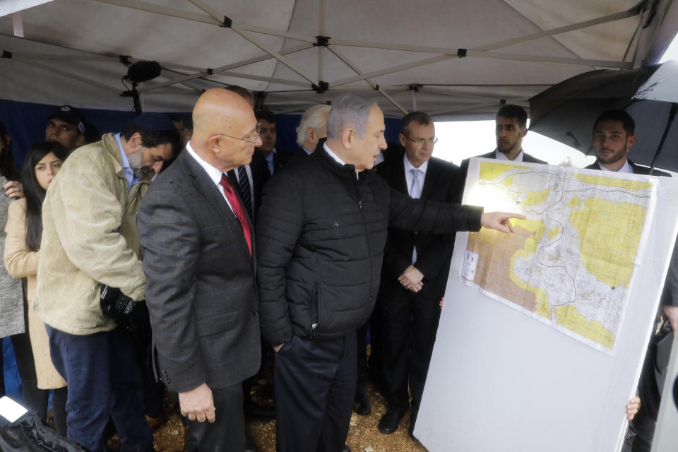 FILE - In this Feb. 24, 2020, file photo, Israeli Prime Minister Benjamin Netanyahu checks the area map during visit to Ariel settlement in the West Bank. Now that Prime Minister Benjamin Netanyahu has secured a new term in office, there’s little to prevent him from annexing large parts of the West Bank as early as this summer. Netanyahu has broad support in the new parliament and a friendly ally in the White House for his long-promised goal. Annexation, the likely death blow to faded Palestinian hopes for independence, will be high on the agenda of U.S. secretary of state Mike Pompeo’s blitz visit to Jerusalem next week. (AP Photo/Sebastian Scheiner, Pool, File)