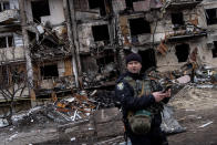 <p>Ce policier ukrainien se tient dos à un immeuble de Kiev détruit par des tirs russes. Les dégâts sont nombreux. Au terme du premier jour de conflit, ce sont 137 Ukrainiens, civils et militaires, qui sont morts. (Chris McGrath/Getty Images)</p> 