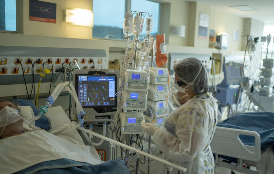 A medical worker treats a COVID-19 patient at the intensive care unit at the Oceanico hospital, in Niteroi, Brazil, Friday, Dec. 11, 2020. Cases of COVID-19 are rising again in the country with the world’s second-highest confirmed death toll and many hospitals are filling up with patients. (AP Photo/Lucas Dumphreys)