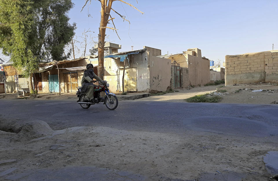 An Afghan man ride motorcycle on a deserted street during fighting between Taliban and Afghan security forces, in Lashkar Gah, Helmand province, southern Afghanistan, Tuesday, Aug. 3, 2021. U.S. and Afghan airstrikes were hitting Taliban targets in southern Helmand province on Wednesday, officials said, in an effort to dislodge the insurgents a day after they captured much of the provincial capital of Lashkar Gah. (AP Photo/Abdul Khaliq)