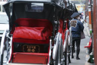 A rickshaw puller wearing a protective face mask to help curb the spread of the coronavirus waits for tourists near Sensoji Temple in the Asakusa district Tuesday, Nov. 24, 2020, in Tokyo. (AP Photo/Eugene Hoshiko)