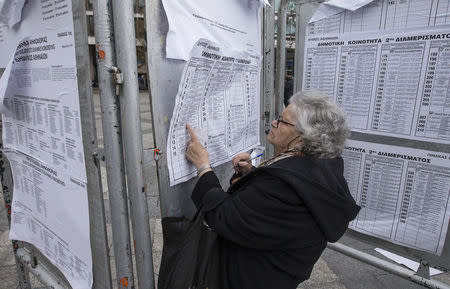 A woman looks at billboards with voting information for the upcoming parliamentary elections in Athens, January 24, 2015. REUTERS/Marko Djurica