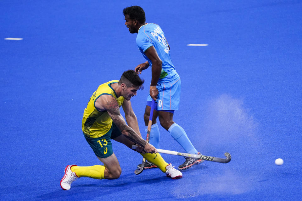 Australia's Blake Govers (13) passes against India's Amit Rohidas (30) during a men's field hockey match at the 2020 Summer Olympics, Sunday, July 25, 2021, in Tokyo, Japan. (AP Photo/John Minchillo)