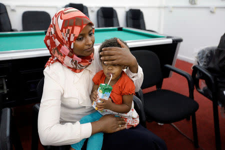 A Sudanese official holds a child of Sudanese Islamic State members who operated in Libya, after Libyan Red Crescent handed them over, in Misrata, Libya August 20, 2017. REUTERS/Ismail Zitouny