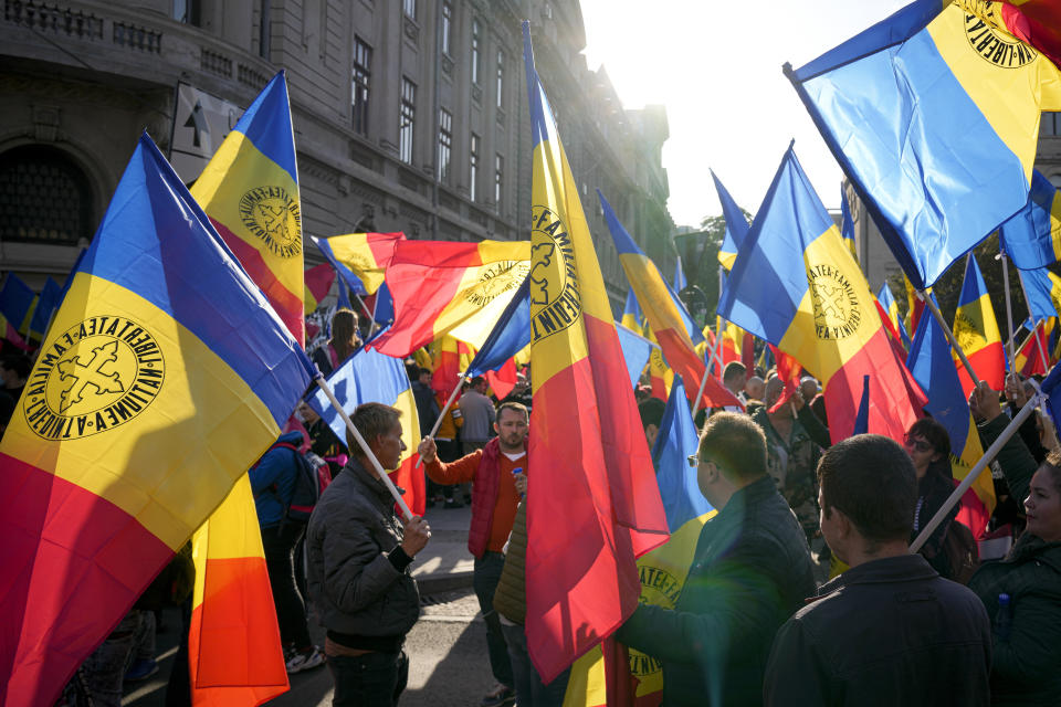 People wave flags during an anti-government protest organised by the far-right Alliance for the Unity of Romanians or AUR, in Bucharest, Romania, Saturday, Oct. 2, 2021. Thousands took to the streets calling for the government's resignation, as Romania reported 12,590 new COVID-19 infections in the past 24 hour interval, the highest ever daily number since the start of the pandemic. (AP Photo/Vadim Ghirda)
