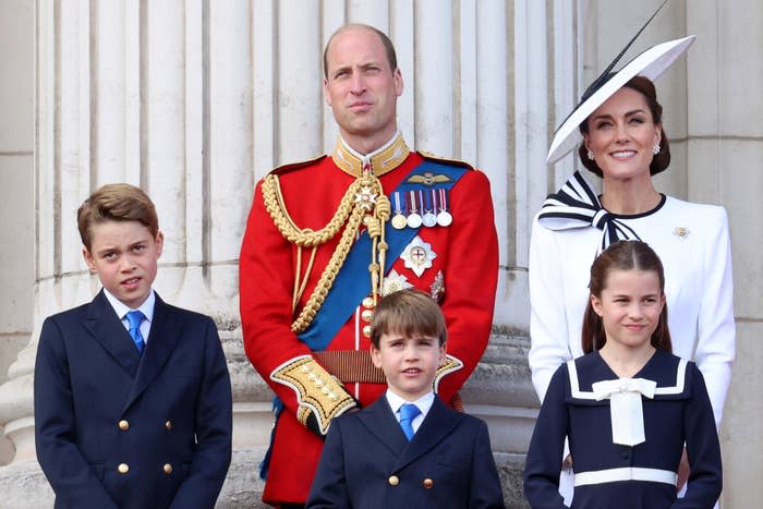 Prince George, Prince William, Prince Louis, Catherine (Princess of Wales), and Princess Charlotte stand together. William wears a decorated military uniform