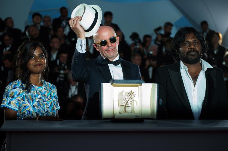 Director Jacques Audiard (C) poses with Kalieaswari Srinivasan and Jesuthasan Antonythasan after he was awarded with the Palme d'Or for his film "Dheepan", during the Cannes Film Festival on May 24, 2015