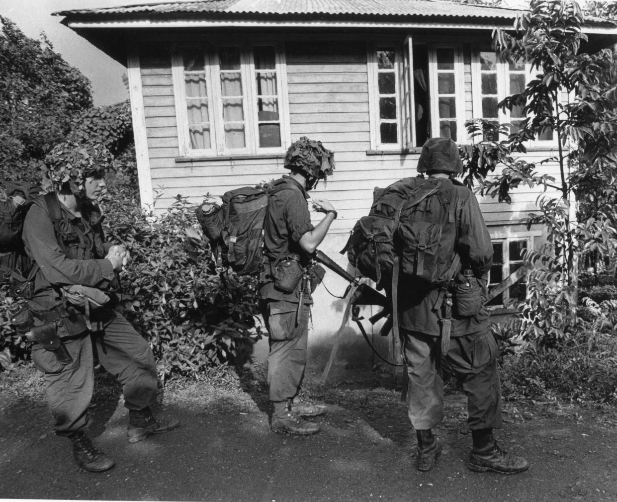 Troops with B Company, 2nd Battalion, 505th Parachute Infantry Regiment check a house near Pearls Airport in Grenada in November 1983.