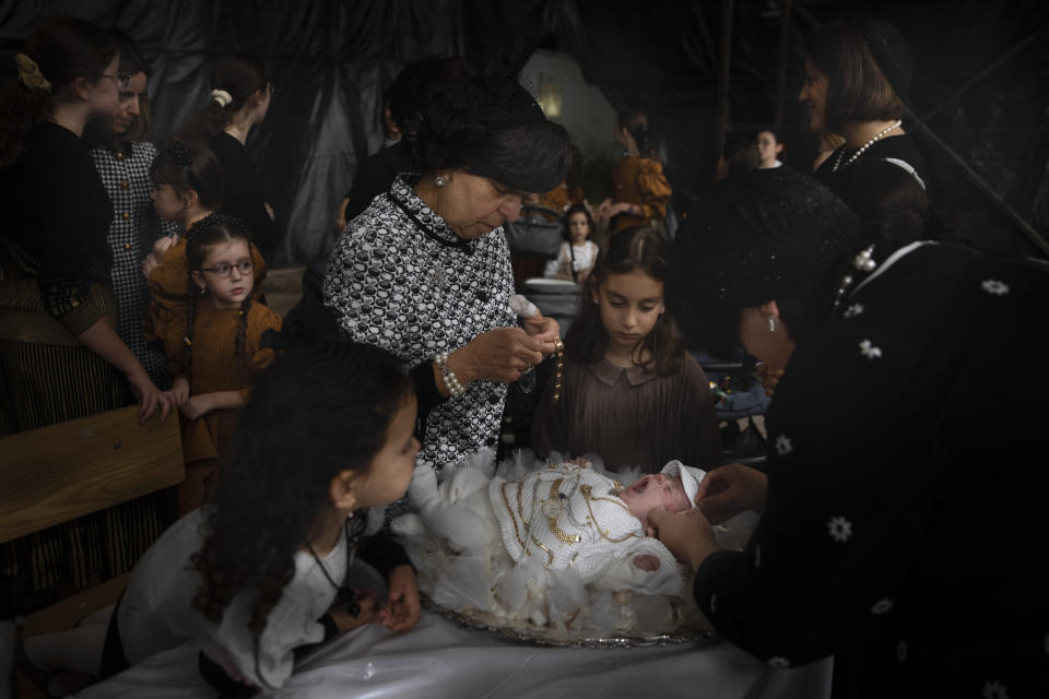 Ultra-Orthodox Jewish women adorn 30-day-old Yossef Tabersky, the great grandchild of the chief rabbi of the Lelov Hassidic dynasty, during the "Pidyon Haben" ceremony in Beit Shemesh, Israel, Thursday, Sept. 16, 2021. The Pidyon Haben, or redemption of the firstborn son, is a Jewish ceremony hearkening back to the biblical exodus from Egypt. (AP Photo/Oded Balilty)