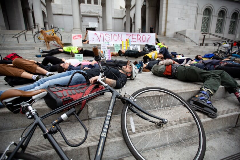 Los Angeles, CA., December 3, 2019: Traffic safety advocates hold a "die-in" on the steps of L.A. City Hall on Tuesday December, 3, 2019. to protest the city's lack of progress on Vision Zero, a program created by Mayor Eric Garcetti in 2015 that aims to eliminate traffic deaths on city streets by 2025.(Jason Armond / Los Angeles Times)