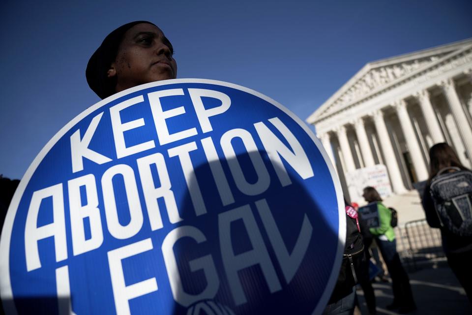 An activist holds a sign as she counter-protests in front of the the U.S. Supreme Court.