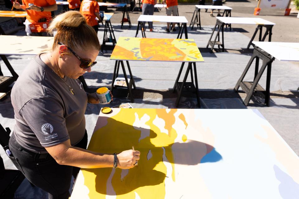 Melanie Jojola works on a paint-by-number mural in the community room at Freedom Landing in Salt Lake City on Wednesday, July 12, 2023. Mural artists Isaac Caruso and Leslie Minnis created mural outlines and volunteers helped fill them in with the correct paint colors. | Megan Nielsen, Deseret News