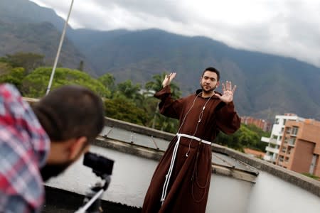 Venezuelan priest Luis Antonio Salazar records a video for his social media on a rooftop in Caracas