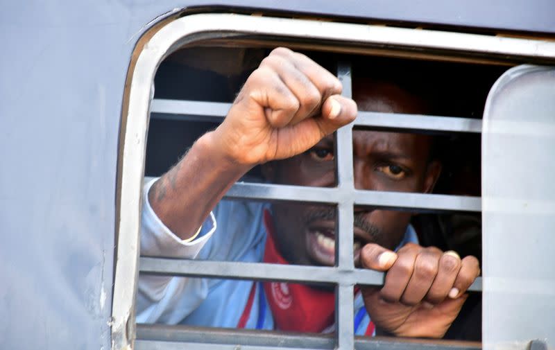 FILE PHOTO: Ugandan presidential candidate Robert Kyagulanyi reacts from inside a police van, in Luuka district