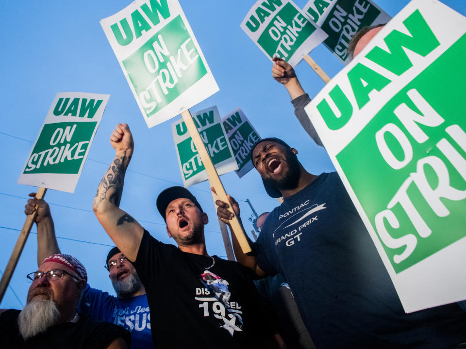 Los empleados de General Motors Bobby Caughel (izquierda) y James Crump corean lemas de protesta con otros trabajadores de GM y miembros del sindicato United Auto Workers y simpatizantes sindicales en las afueras de la planta de ensamblaje de Flint, Michigan, el lunes 16 de septiembre de 2019. (Jake May/The Flint Journal vía AP)