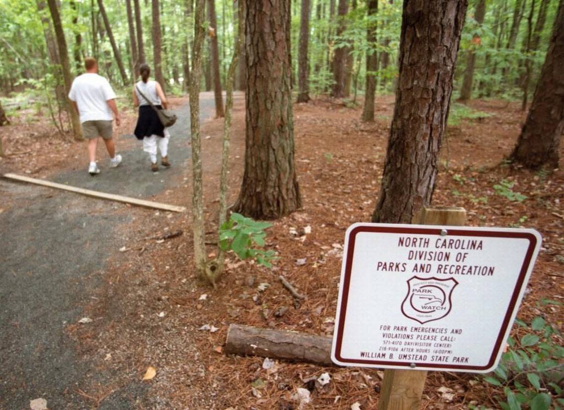 Two hikers set off into the woods at Umstead State Park.