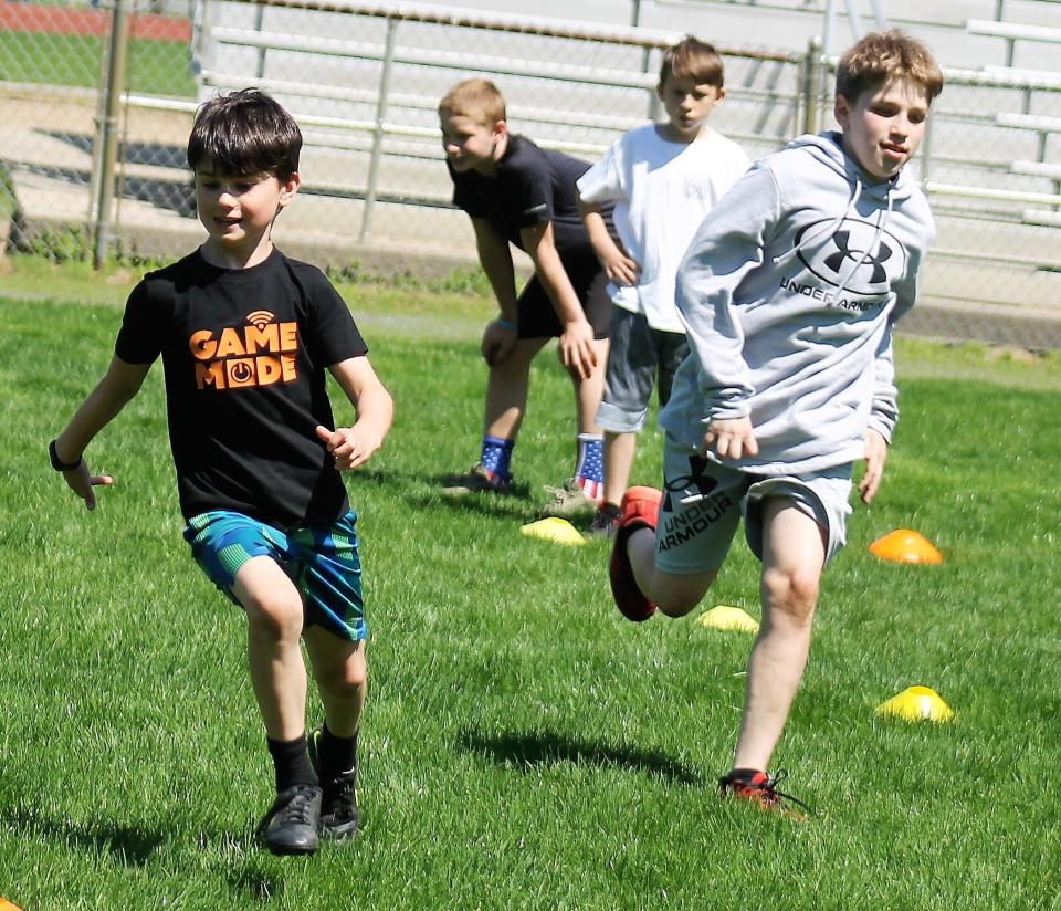 Shane Donald, left, and Drew Reilly participate in speed and agility drills during Saturday's football clinic conducted by former Patriots running back Jonas Gray at Roger Allen Park in Rochester.