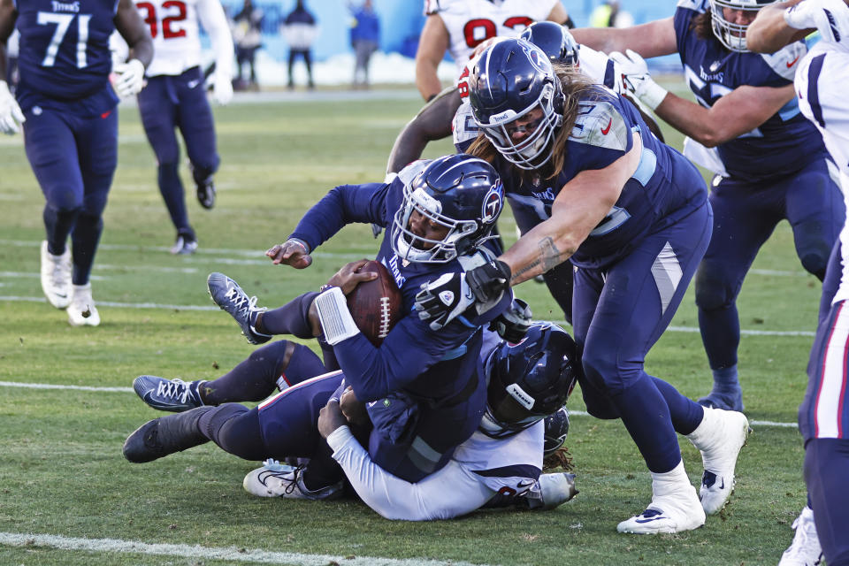 Tennessee Titans quarterback Malik Willis (7) is pushed over the goal line by guard Jordan Roos (70) as he is tackled by Houston Texans defensive tackle Maliek Collins, bottom, during an NFL football game Saturday, Dec. 24, 2022, in Nashville, Tenn. (AP Photo/Wade Payne)