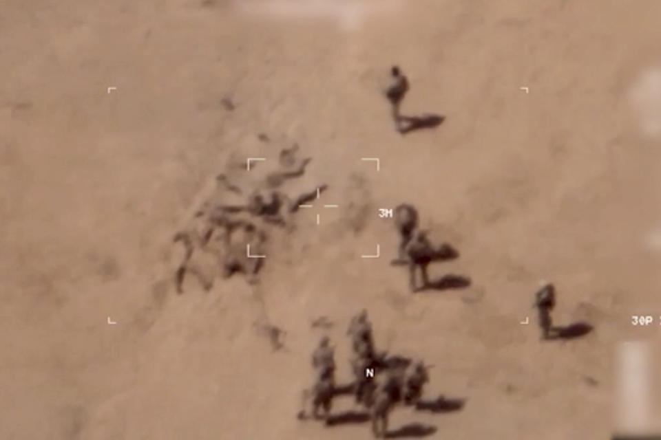 This image taken from a video shows soldiers burying bodies near an army base in northern Mali. The French military says it has videos of Russian mercenaries burying bodies near an army base in northern Mali which it says is part of a smear campaign against the French who handed control of the base to Malian forces earlier this week. Aerial surveillance taken by the French military early Thursday and provided to The Associated Press show what appear to be 10 Caucasian soldiers covering approximately a dozen Malian bodies with sand near the Gossi military base, according to a French military officer who spoke on condition of anonymity because he was not authorized to speak to the press. (French Army via AP)