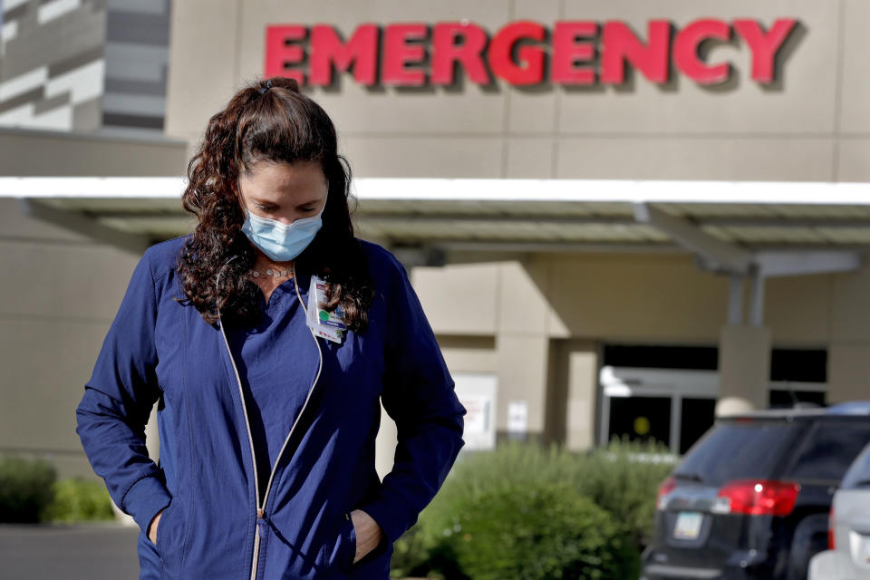 Caroline Maloney stands outside HonorHealth's Scottsdale Osborn Medical Center at the end of her overnight shift early Friday, June 26, 2020 in Scottsdale, Ariz. Arizona nurses and doctors find themselves on the frontline as the coronavirus rips through the state, making it one of the world's hot spots. (AP Photo/Matt York)