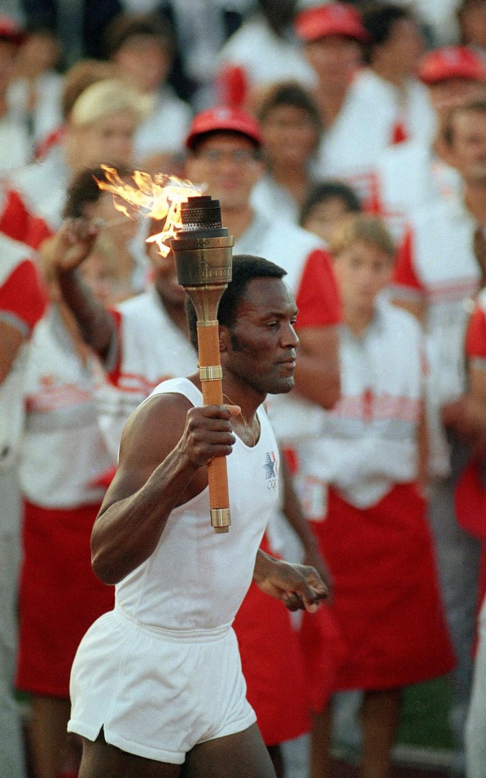 Rafer Johnson carrying the Olympic torch through the Los Angeles Memorial Coliseum before lighting the Olympic flame and formally launching the 1984 Games - Peter Leabo/ AP