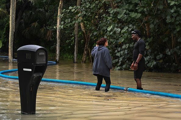 People work to cleanup a flooded backyard after Hurricane Nicole's landfall, in Vero Beach, Florida, on November 10, 2022. - Tropical Storm Nicole slowed after making landfall in the US state of Florida, meteorologists said Thursday. (Photo by Eva Marie UZCATEGUI / AFP) (Photo by EVA MARIE UZCATEGUI/AFP via Getty Images)