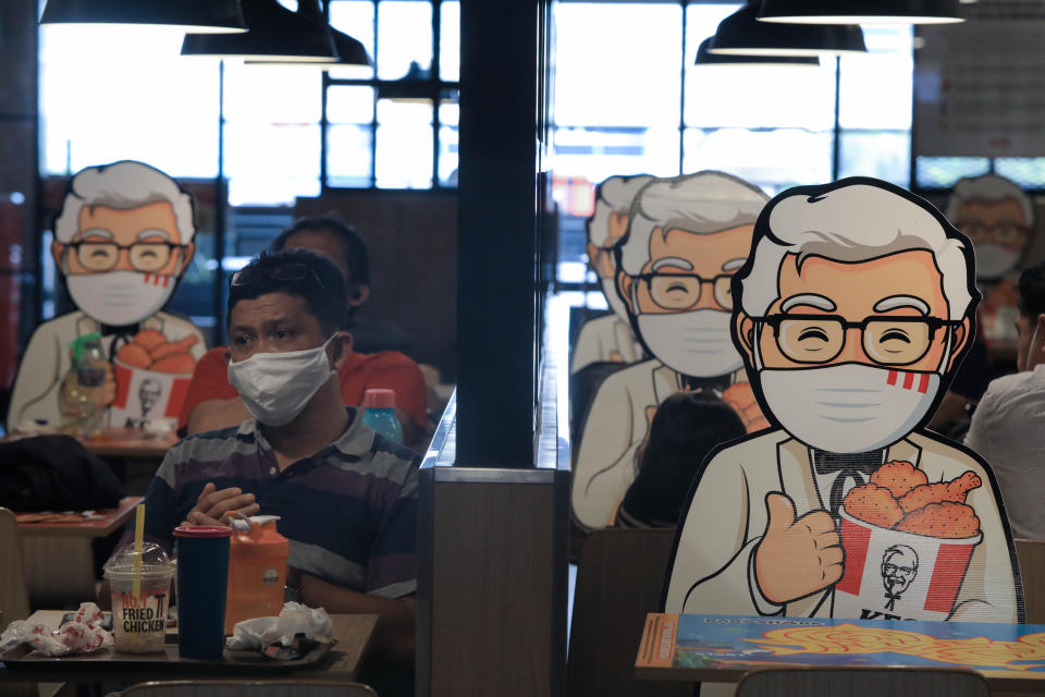 A customer sits next to a Colonel Sanders' character mounted at a table as a way of maintaining the social distance, a precaution against the spread of coronavirus (covid-19) at KFC. (Photo by Jovan Triniti / SOPA Images/Sipa USA)