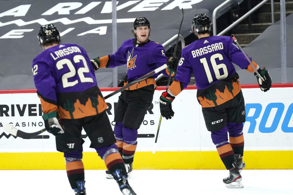 Arizona Coyotes defenseman Jakob Chychrun (6) celebrates with left wing Johan Larsson (22) and center Derick Brassard (16) after scoring a goal against the Minnesota Wild in the second period during an NHL hockey game, Saturday, March 6, 2021, in Glendale, Ariz. (AP Photo/Rick Scuteri)