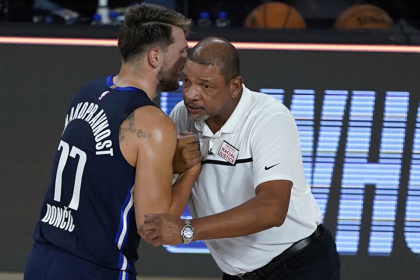 LAKE BUENA VISTA, FLORIDA - AUGUST 06: Luka Doncic #77 of the Dallas Mavericks talks to Head coach Doc Rivers.