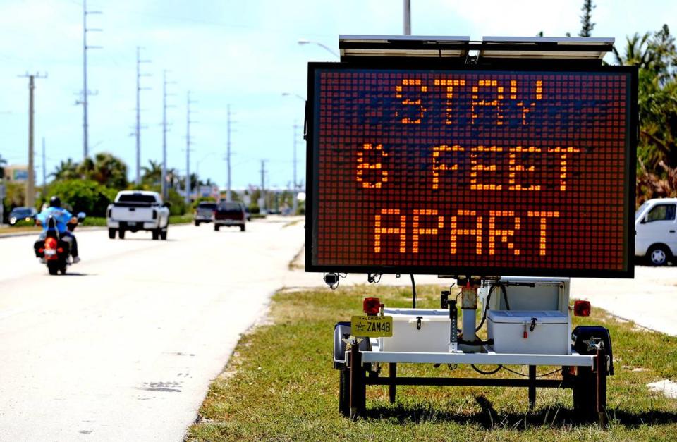 Signs along U.S. 1 in Marathon in the Florida Keys ask drivers to practice social distancing as the Keys prepare to shut down on Sunday closing hotels and restaurants because of Coronavirus fears, March 21, 2020.