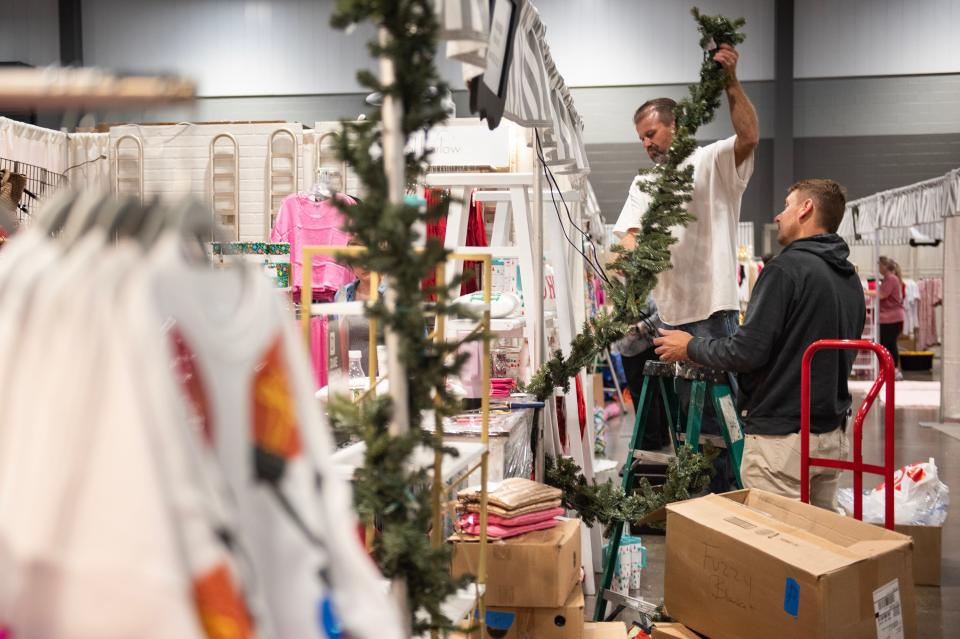 Barry Grant, left, assistant, and Chris Benton, right, Impromptu owner, hang garland on Monday, Oct. 30, to decorate the Impromptu booth for the Mistletoe Marketplace held by the Junior League of Jackson with varying events and shopping from Wednesday, Nov. 1, 2023, to Saturday, Nov. 4, 2023, at the Mississippi Trade Mart in Jackson.