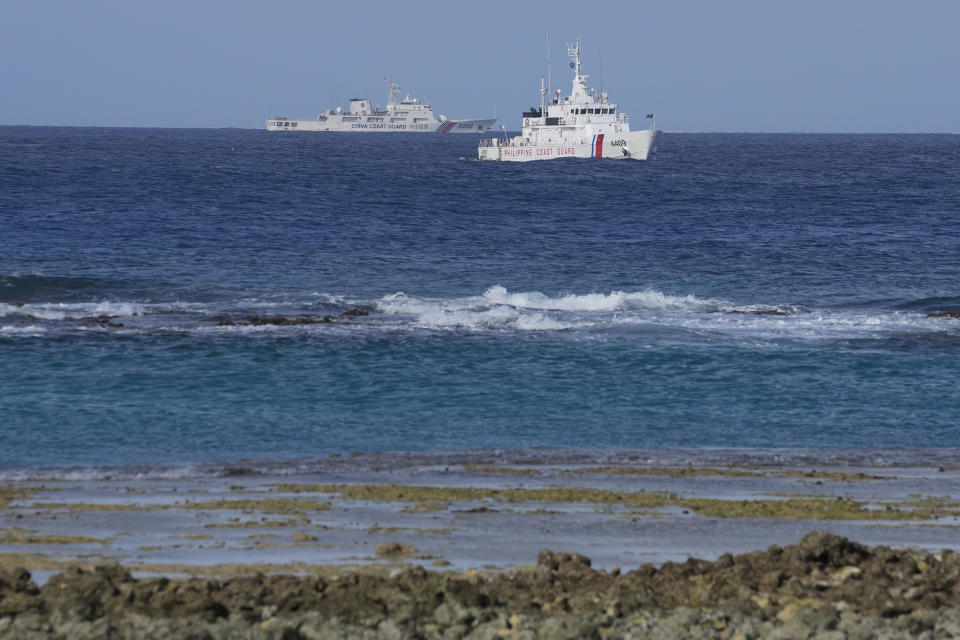 A Chinese coast guard vessel passes by a Philippine coast guard ship near the Philippine-occupied Thitu island, locally called Pag-asa island, on Friday, Dec. 1, 2023 at the disputed South China Sea. The Philippine coast guard inaugurated a new monitoring base Friday on a remote island occupied by Filipino forces in the disputed South China Sea as Manila ramps up efforts to counter China's increasingly aggressive actions in the strategic waterway. (AP Photo/Aaron Favila)