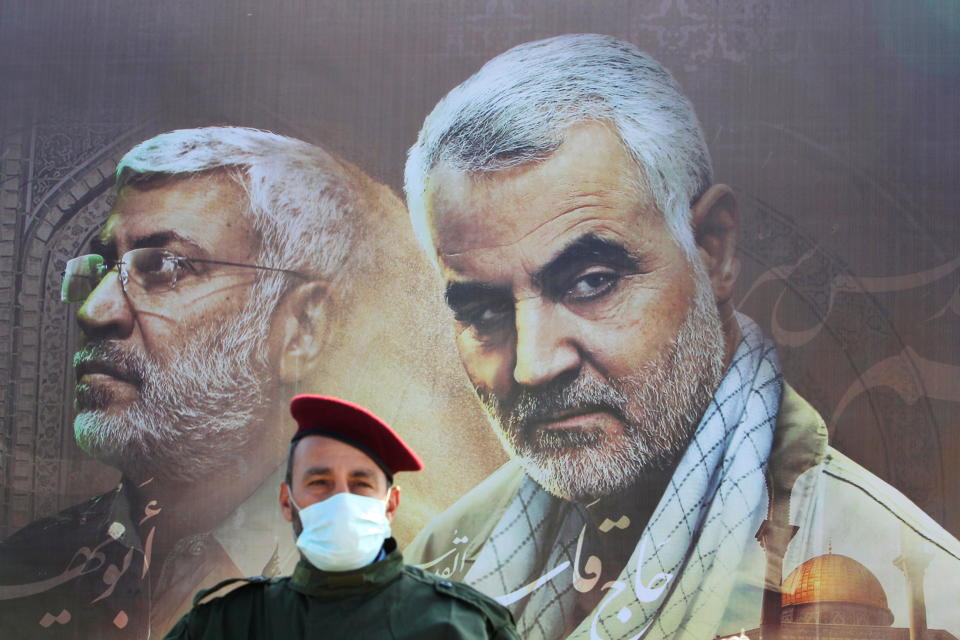 A member of Lebanon's Hezbollah stands in front of a picture depicting senior Iranian military commander General Qassem Soleimani (right) and Iraqi militia commander Abu Mahdi al-Muhandis who were killed in a U.S. attack, during a ceremony marking the first anniversary of their killing in the southern village of Khiam, Lebanon, January 3, 2021. / Credit: AZIZ TAHER/REUTERS