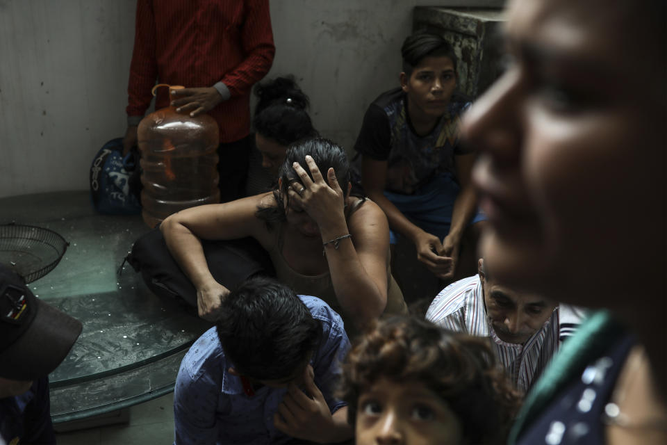 Detained migrants stand together in a storage room at the back of the Azteca Hotel where they tried to hide from Mexican immigration agents conducting a raid in Veracruz, Mexico, Thursday, June 27, 2019. Under increasing U.S. pressure to reduce the flow of hundreds of thousands of Central Americans through Mexican territory, Mexico's government has stepped up enforcement. (AP Photo/Felix Marquez)