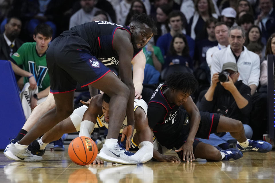 Villanova's Eric Dixon, center, struggles for a loose ball between UConn's Adama Sanogo, left, and Tristen Newton during the second half of an NCAA college basketball game, Saturday, March 4, 2023, in Philadelphia. (AP Photo/Matt Slocum)