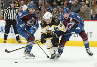 Boston Bruins right wing David Pastrnak, center, drives between Colorado Avalanche center Alex Newhook, left, and defenseman Cale Makar during the second period of an NHL hockey game Wednesday, Dec. 7, 2022, in Denver. (AP Photo/David Zalubowski)