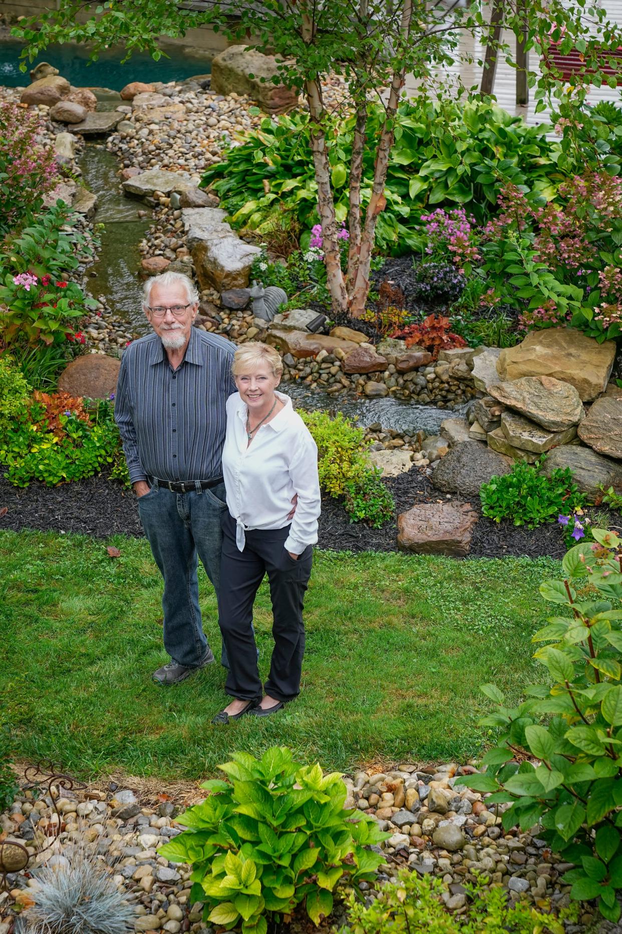 Standing in their back yard surrounded by lush plants, a variety of stones and a waterfall trickling down to a pond, Carolyn Sue Jones and Bruce Jones are winners of the Dispatch Backyard Garden Awards.