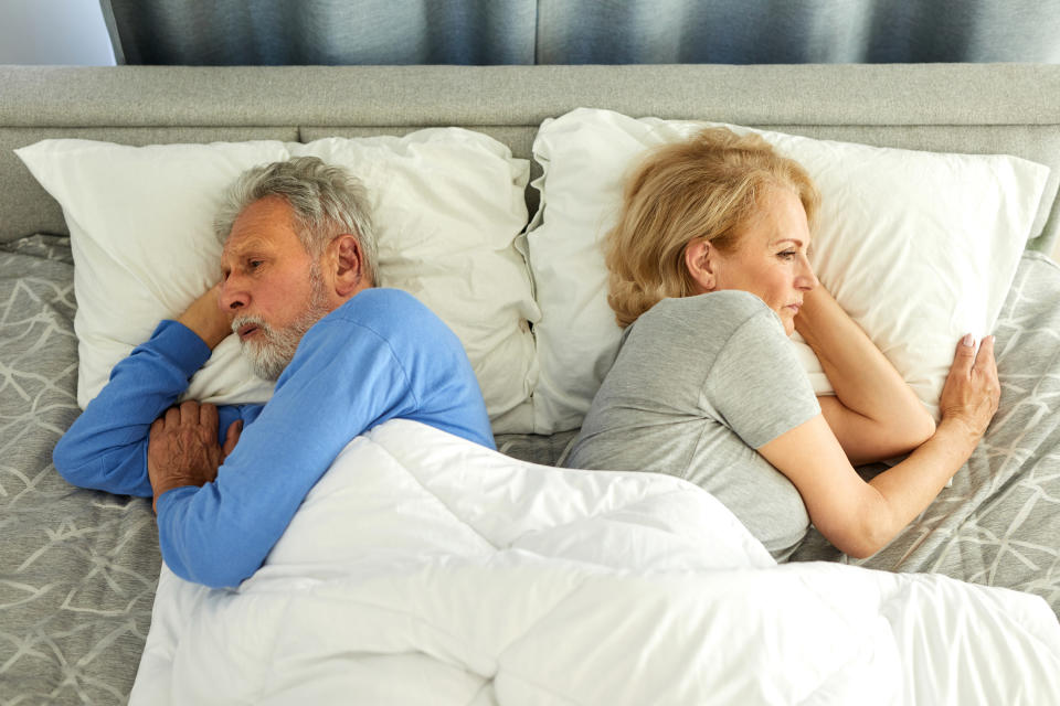 Old couple ignoring each other in the bedroom