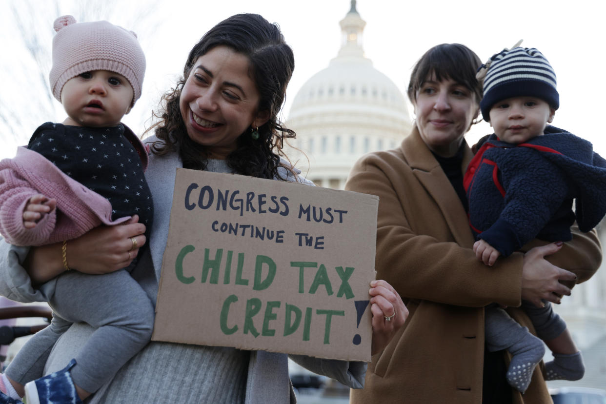 Local residents, Cara Baldari and her nine-month-old daughter Evie (L) and Sarah Orrin-Vipond and her eight-month-old son Otto (R), join a rally in front of the U.S. Capitol December 13, 2021 in Washington, DC. (Credit: Alex Wong/Getty Images)