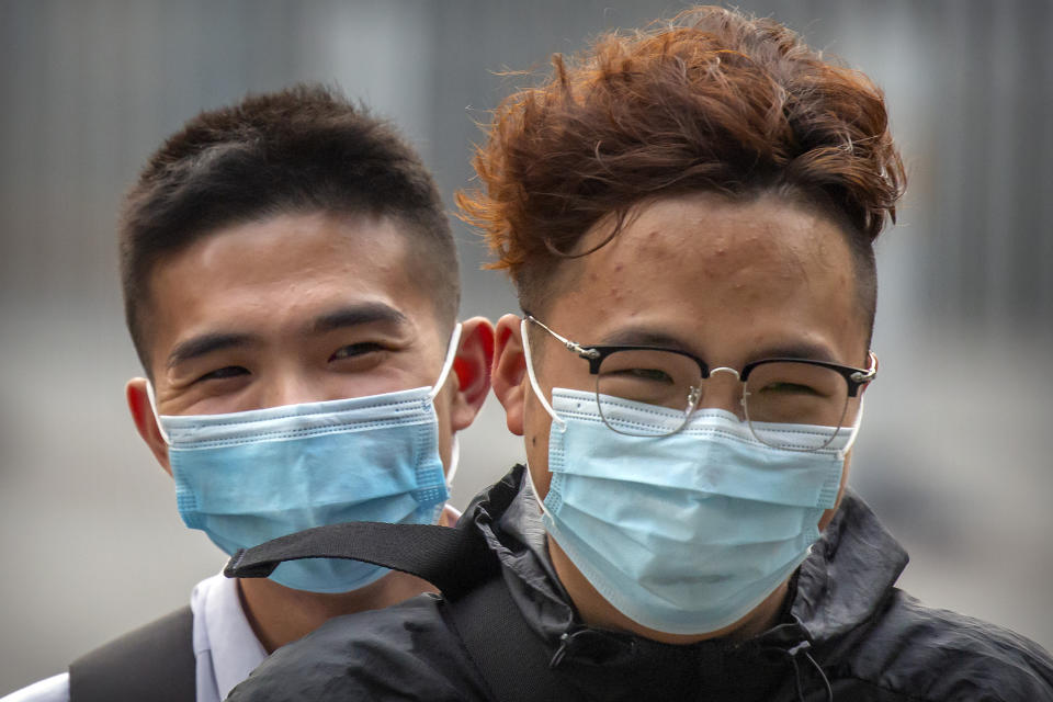 People wearing face masks to protect against the coronavirus ride a motor scooter in Beijing, Wednesday, July 29, 2020. China reported more than 100 new cases of COVID-19 on Wednesday as the country continues to battle an outbreak in Xinjiang. (AP Photo/Mark Schiefelbein)