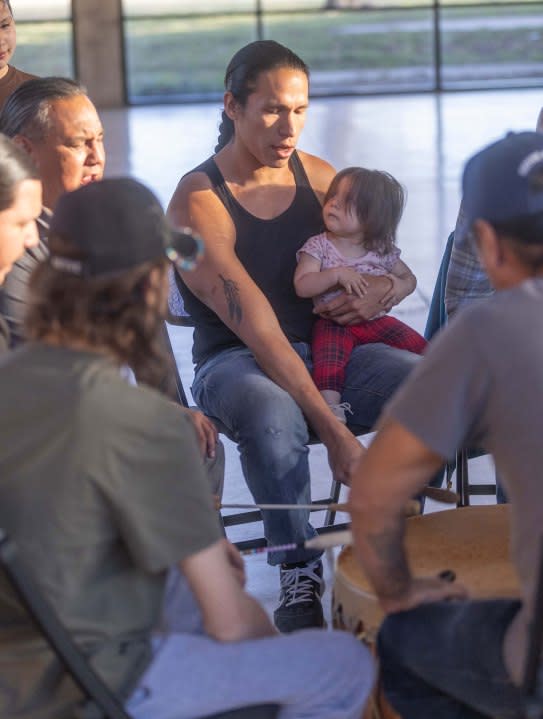 Ben Eagle Feather and his daughter, Wren, 11 months, participate in the drum circle with members of Prairie Rose Wellbriety, a group for Native Americans in recovery, for people trying to get sober, or friends and family supporting them. (Jeff Tuttle / KMUW)