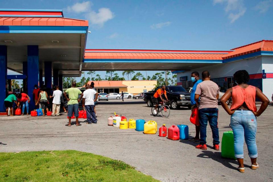 Residents wait in line to fill their containers with gasoline before the arrival of Hurricane Isaias in Freeport, Grand Bahama, Bahamas, Friday, July 31, 2020. (AP Photo/Tim Aylen)