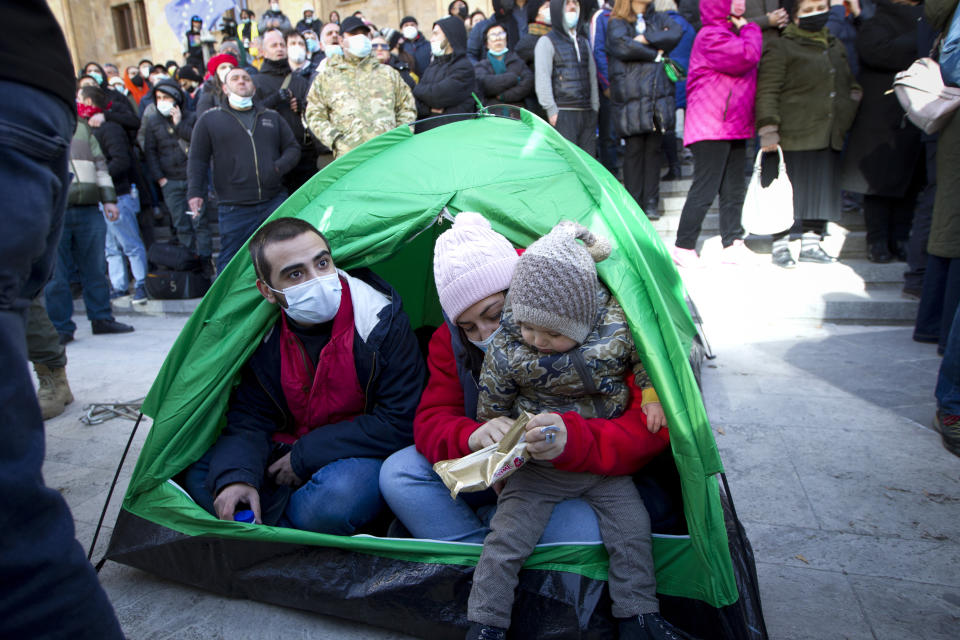 Georgian opposition supporters attend a rally following the detention of the United National Movement party leader Nika Melia, Tbilisi, Georgia, Tuesday, Feb. 23, 2021. Protesters denouncing the arrest of the head of Georgia's main opposition party have set up tents outside the country's parliament building and blocked the capital's main avenue. Tensions in Georgia have been strong since the October parliamentary election that the opposition is demanding be rerun. (AP Photo/Shakh Aivazov)