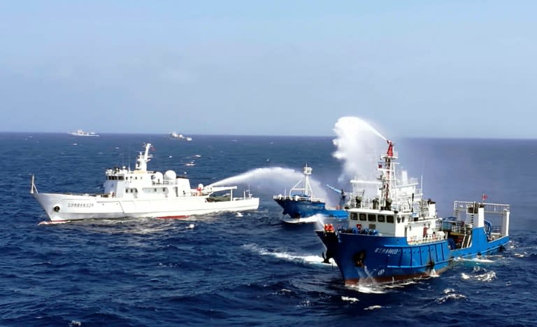 Chinese ships put out a fire on a mock cargo vessel during an emergency drill in the South China Sea near Sansha