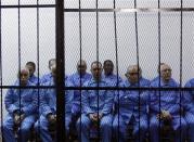 Officials of Muammar Gaddafi's government sit behind bars during a hearing at a courtroom in Tripoli April 14, 2014. REUTERS/Ismail Zitouny